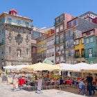 PORTO, PORTUGAL - JUNE 5, 2015: Colorful houses and outdoor cafes at historic Ribeira Square of Porto, a popular place for tourists and locals., License Type: media, Download Time: 2025-02-25T21:56:50.000Z, User: katelyn.perry_lonelyplanet, Editorial: true, purchase_order: 65050 - Digital Destinations and Articles, job: wip, client: wip, other: katelyn perry