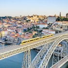 A metro train crosses the Dom Luiz bridge with the historic city of Porto beyond.
148234274
RFC,  Shutterstock,  day,  city,  blue,  view,  tram,  port,  porto,  douro,  ponte,  river,  metro,  sunny,  oporto,  center,  bridge,  railway,  history,  downtown,  daylight,  landmark,  building,  portugal,  historic,  cityscape,  horizontal,  architecture,  dom luiz,  old city,  Aerial View,  Arch,  Architecture,  Bridge,  Building,  Cityscape,  Outdoors,  Railway,  Train,  Transportation,  Urban,  Vehicle
A metro train crosses the Dom Luiz bridge with the historic city of Porto beyond.